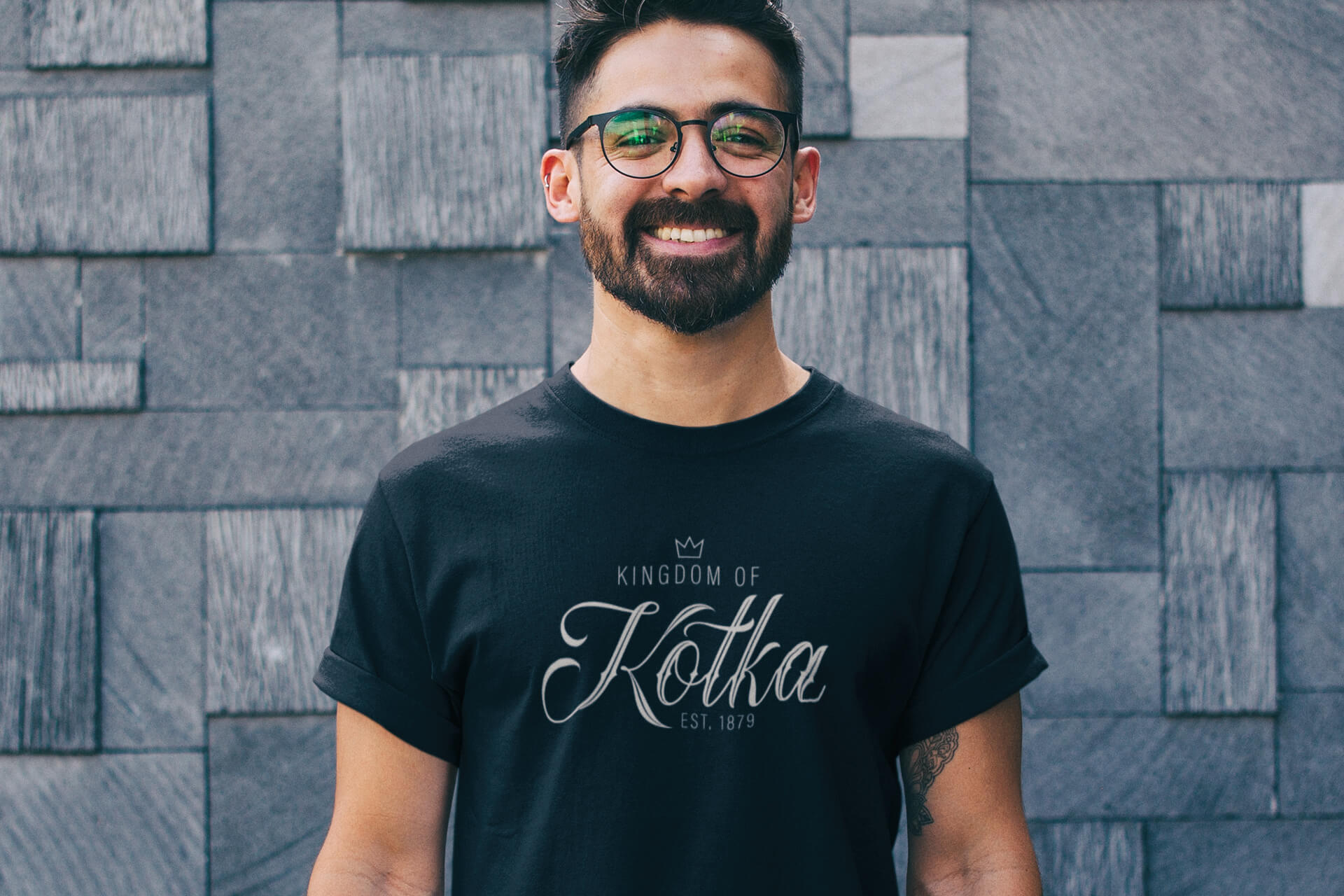 Kingdom Of Kotka -niminen musta miesten T-paita, kuvassa iloinen mies Saunazillan paita päällään.