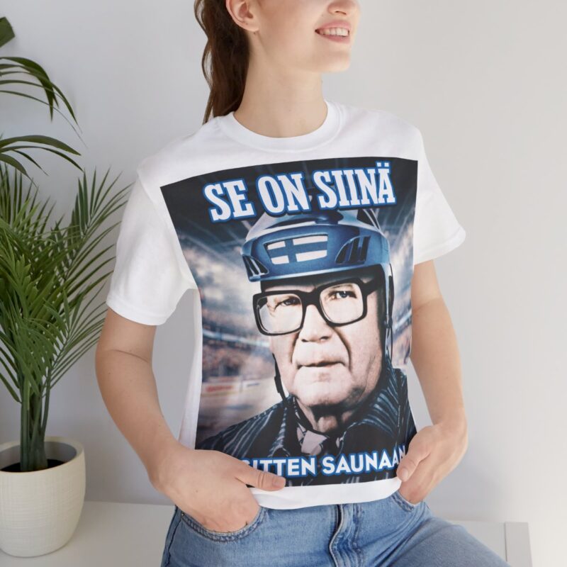 Naisen päällä valkoinen Kekkonen T-paita joka sopii myös miehille. Jääkiekko T-paita joka on samalla myös Kekkonen T-paita, eli kaksi suomalaista klassikkoa yhdessä suositussa tuotteessa. Kekkonen paita sopii jääkiekkoareenalle sekä kotikatsomoihin. Se on siinä ja sitten saunaan, sanoo Kekkonen paita ja valkoinen miesten T-paita naisille.