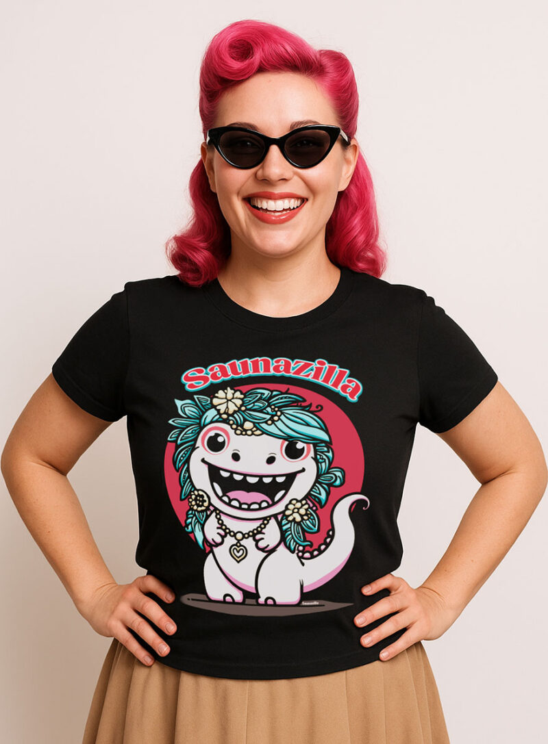 Cure little Saunazilla monster in a fun graphic tee. A pin-up model wearing a trendy black t-shirt with a cartoony monster figure printed on it.